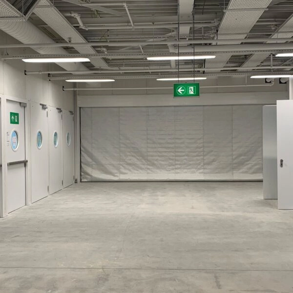 Detail van een brandwerend rolscherm met geleider en zijafdichting